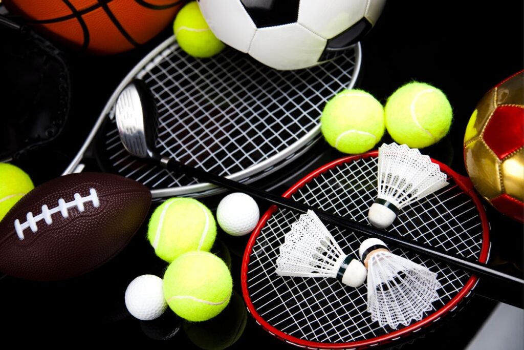 Equipamentos esportivos variados como bolas, raquetes e petecas usados em estratégias de marketing esportivo.