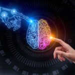 Uma mão humana tocando um cérebro digital dividido em duas cores, azul e rosa, enquanto um braço robótico aponta para ele, sobre um fundo escuro com elementos digitais.